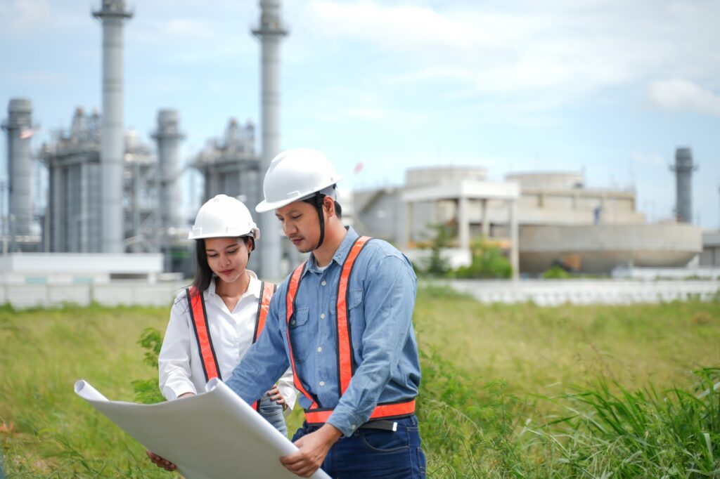 Engineers team Reviewing drawing and Plans on Construction Site at Industrial Power Plant. Project e