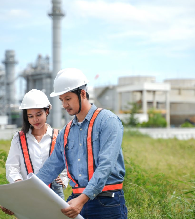 Engineers team Reviewing drawing and Plans on Construction Site at Industrial Power Plant. Project e